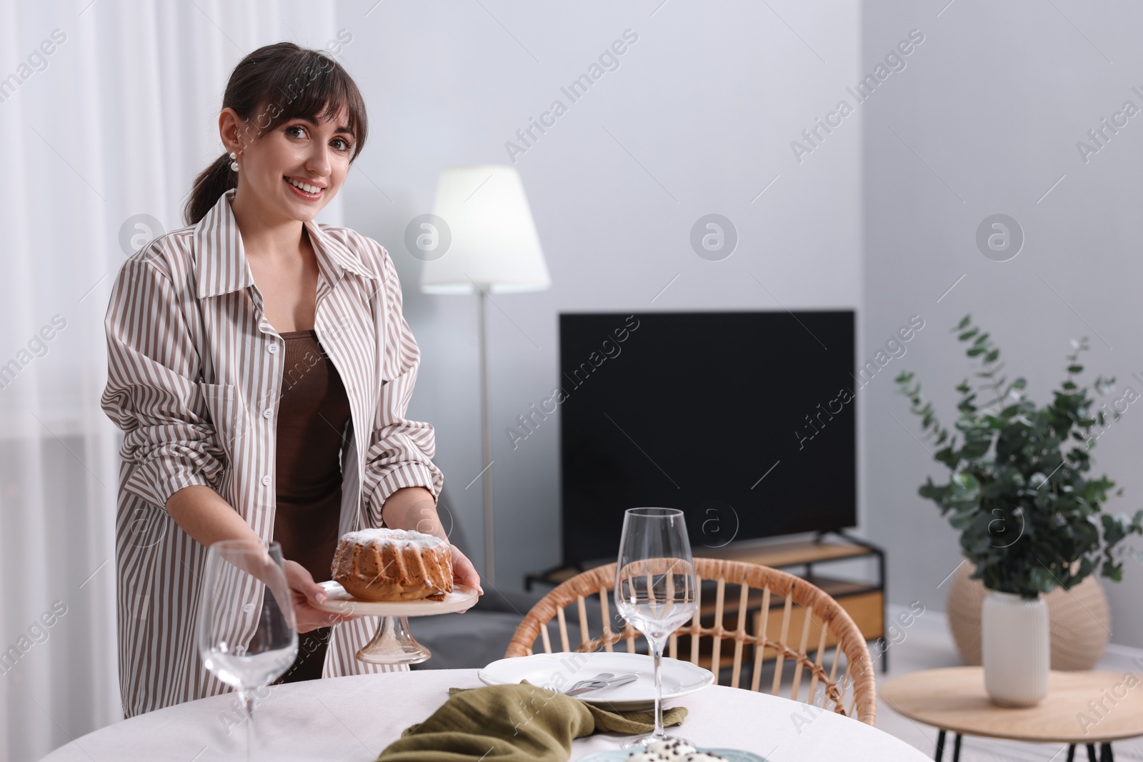 Photo of Woman setting table for dinner at home