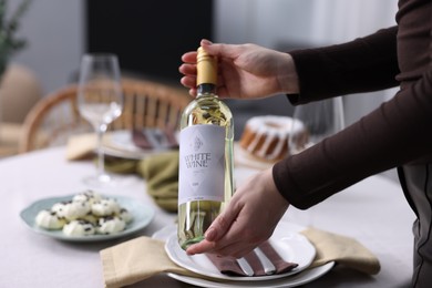 Photo of Woman setting table for dinner at home, closeup