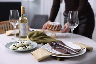 Photo of Woman setting table for dinner at home, closeup