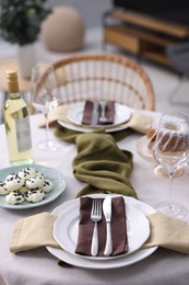 Photo of Festive table setting with dishware, cutlery, glasses, desserts and wine indoors