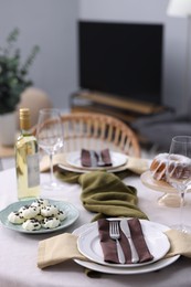 Photo of Festive table setting with dishware, cutlery, glasses, desserts and wine indoors