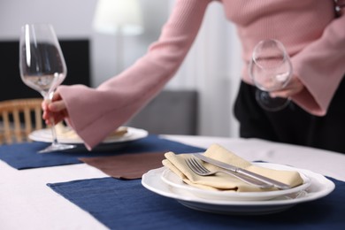 Photo of Woman setting table for dinner at home, closeup