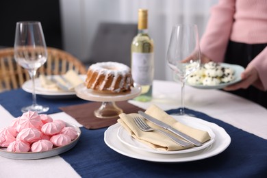 Photo of Woman setting table for dinner at home, closeup