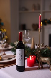 Photo of Festive table setting with dishware, wine and decor indoors