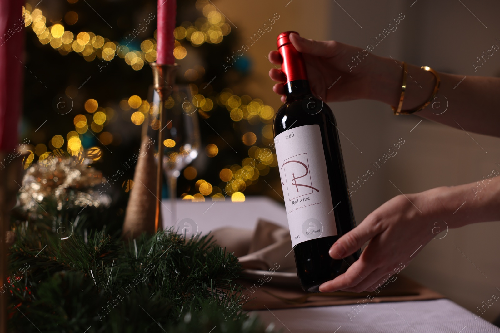 Photo of Woman setting table for Christmas dinner at home, closeup