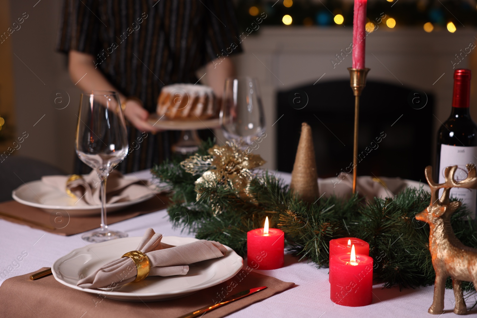 Photo of Woman setting table for Christmas dinner at home, selective focus