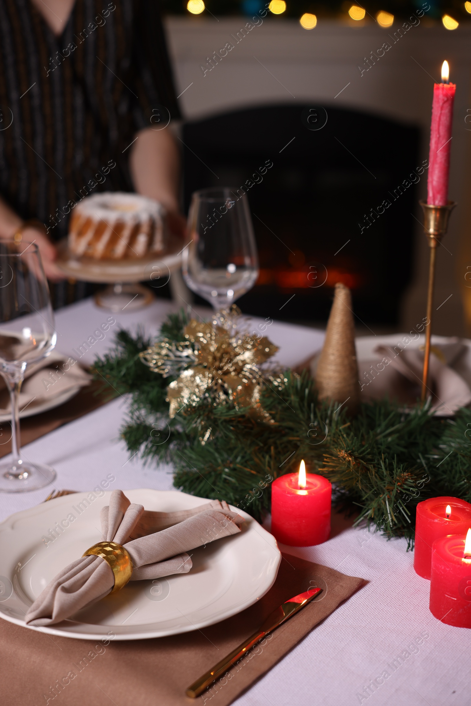 Photo of Woman setting table for Christmas dinner at home, selective focus