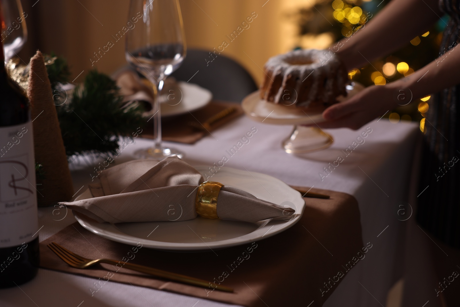 Photo of Woman setting table for Christmas dinner at home, selective focus