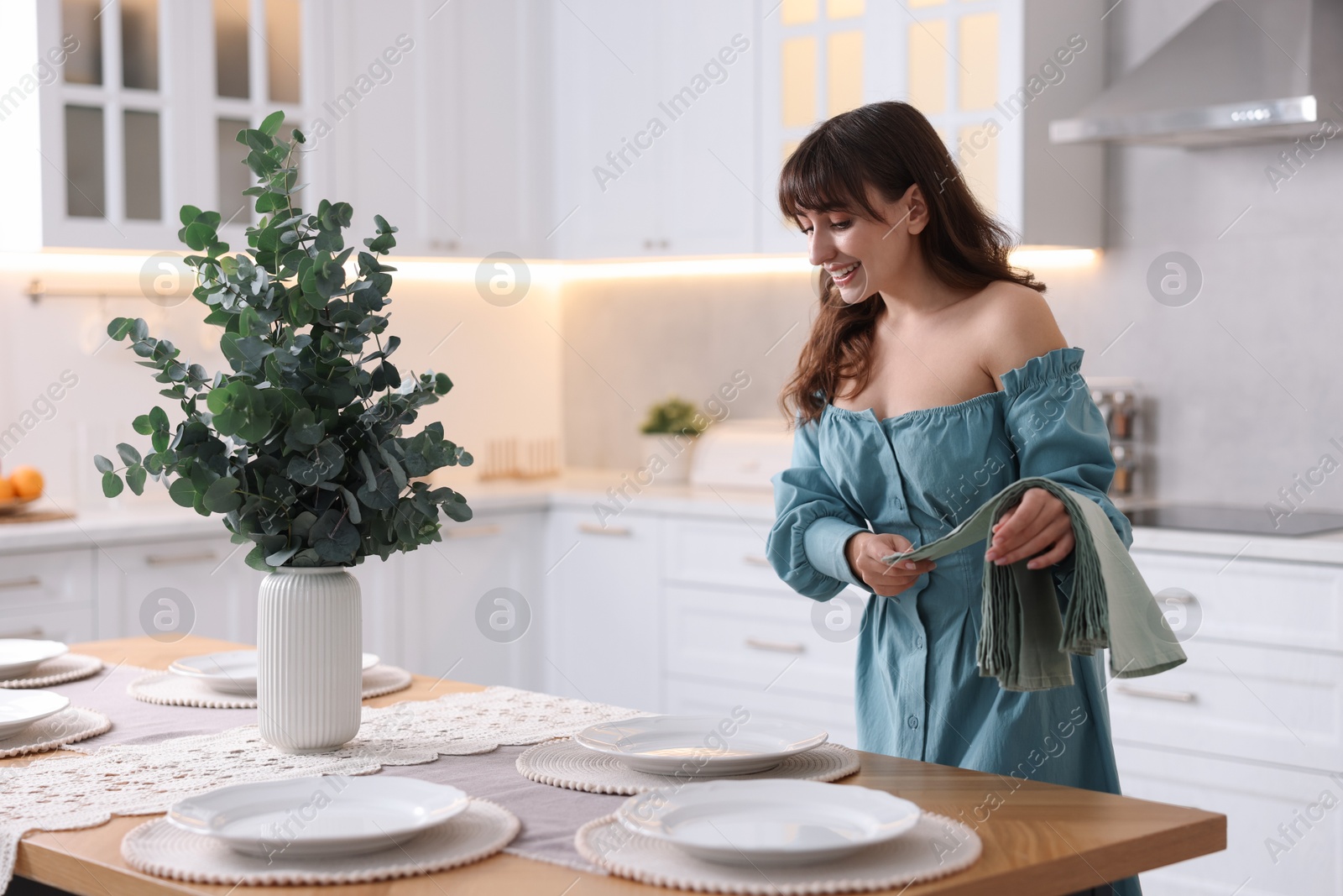 Photo of Woman setting table for dinner at home