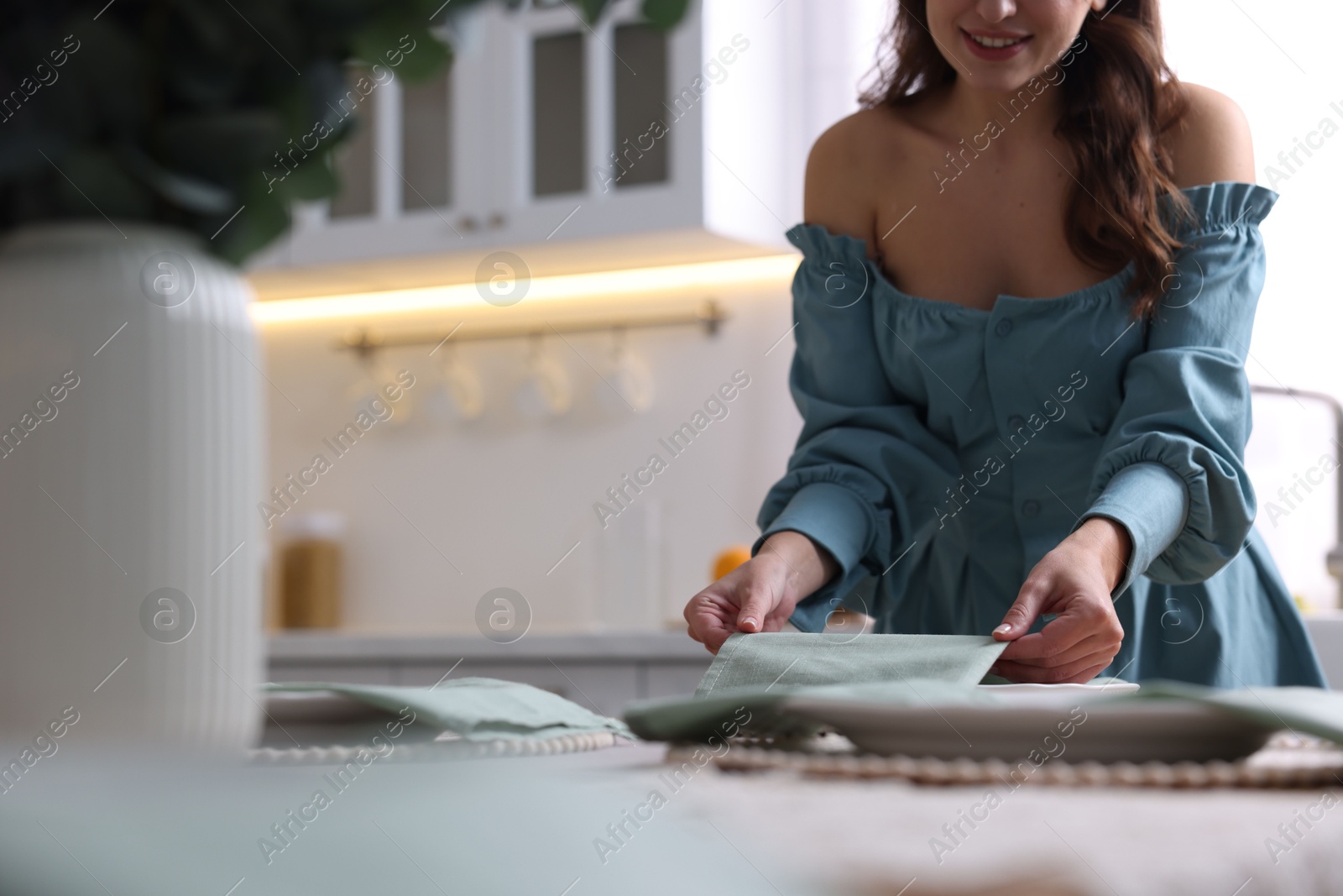 Photo of Woman setting table for dinner at home, closeup. Space for text