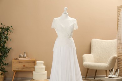 Photo of Beautiful wedding dress on mannequin and shoes in boutique