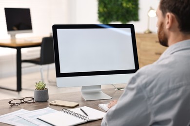 Man working on computer at table in office, closeup