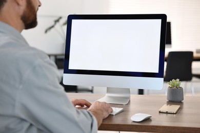 Man working on computer at table in office, closeup