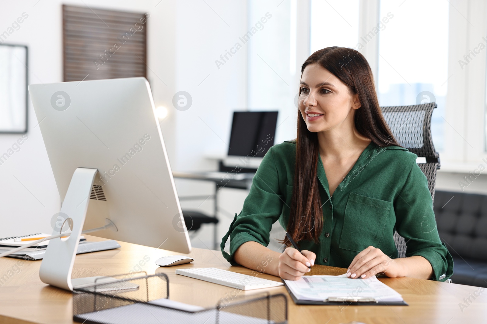 Photo of Woman working with document at table in office