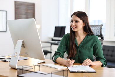 Woman working with document at table in office