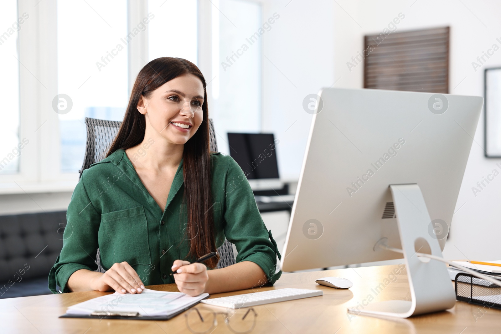 Photo of Woman working with document at table in office