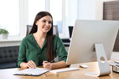 Photo of Woman working with document at table in office