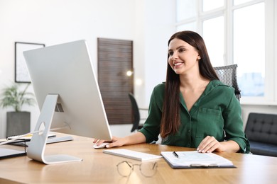 Photo of Woman working on computer at table in office