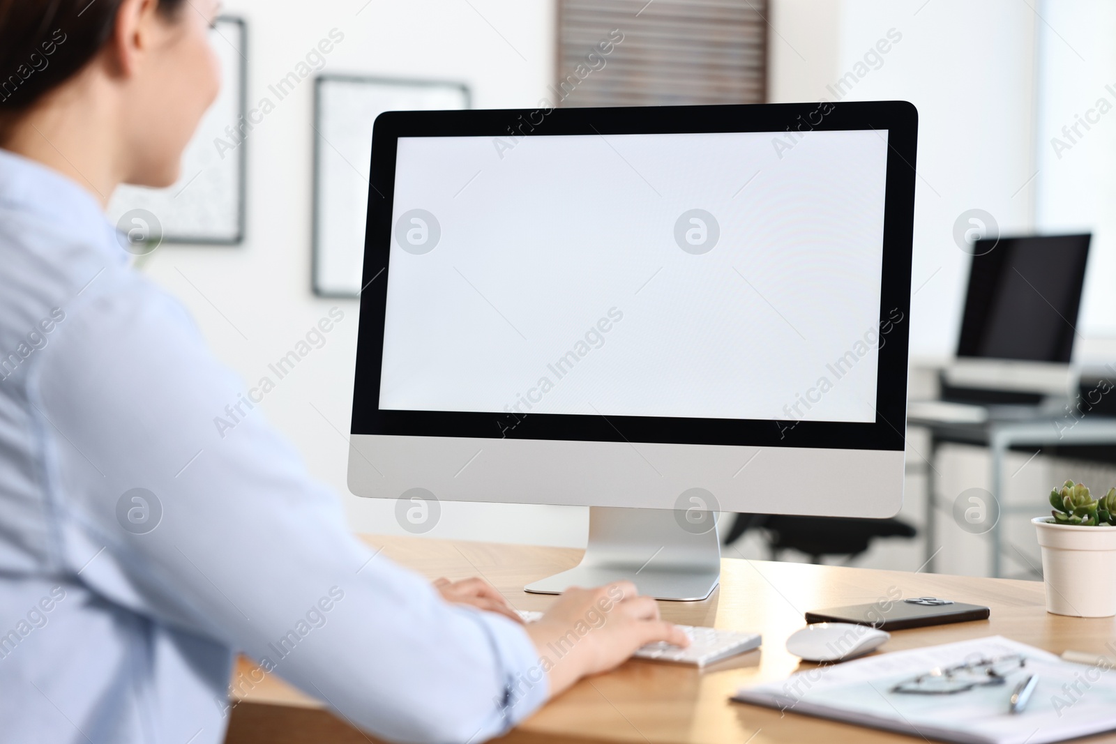 Photo of Woman working on computer at table in office, closeup