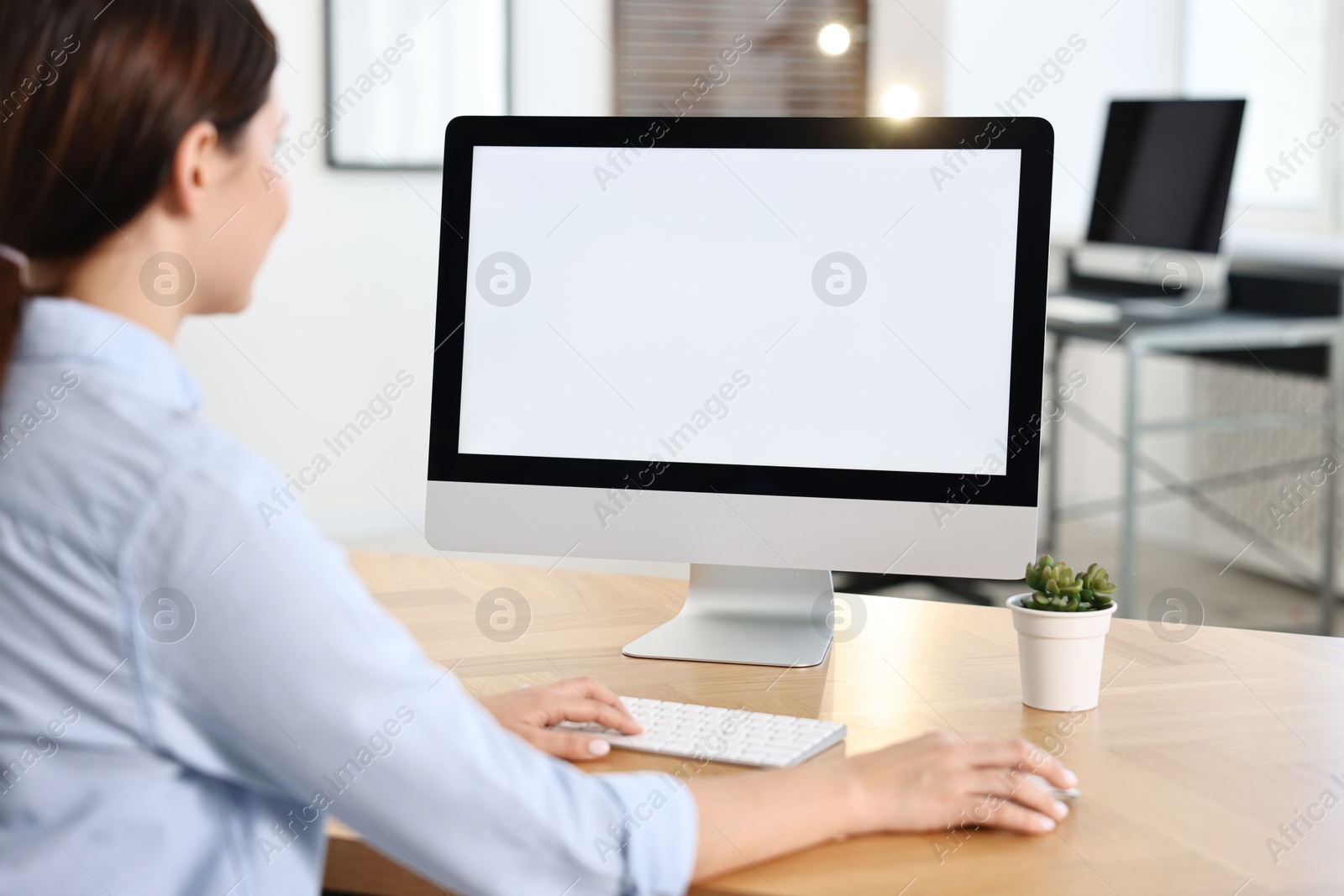 Photo of Woman working on computer at table in office