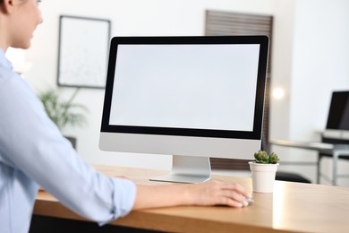 Photo of Woman working on computer at table in office, closeup