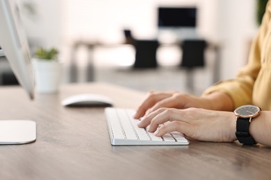 Photo of Woman working on computer at table in office, closeup