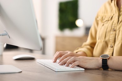 Photo of Woman working on computer at table in office, closeup