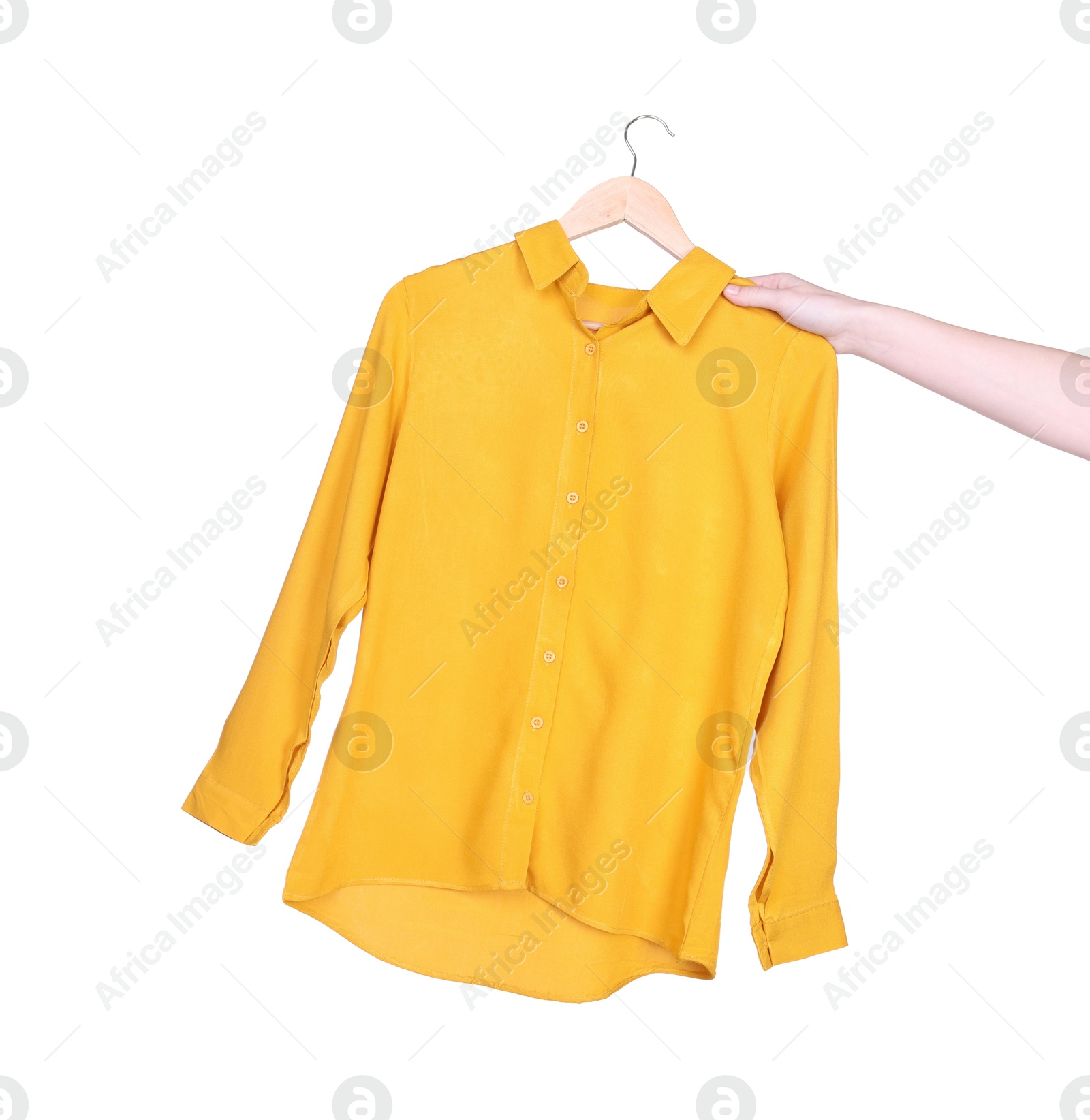 Photo of Woman holding hanger with yellow shirt on white background, closeup