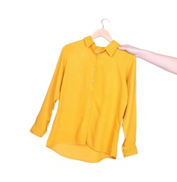 Photo of Woman holding hanger with yellow shirt on white background, closeup