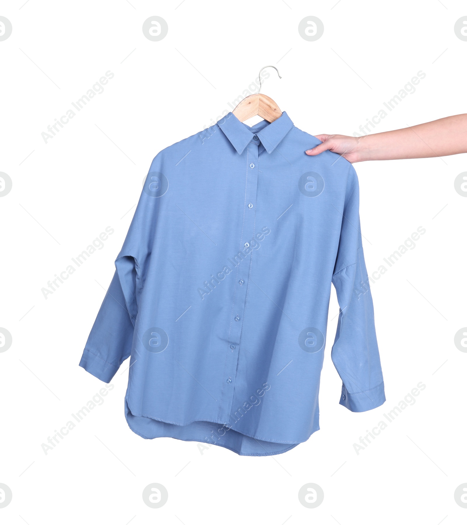 Photo of Woman holding hanger with light blue shirt on white background, closeup