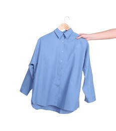 Photo of Woman holding hanger with light blue shirt on white background, closeup