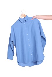 Photo of Woman holding hanger with light blue shirt on white background, closeup