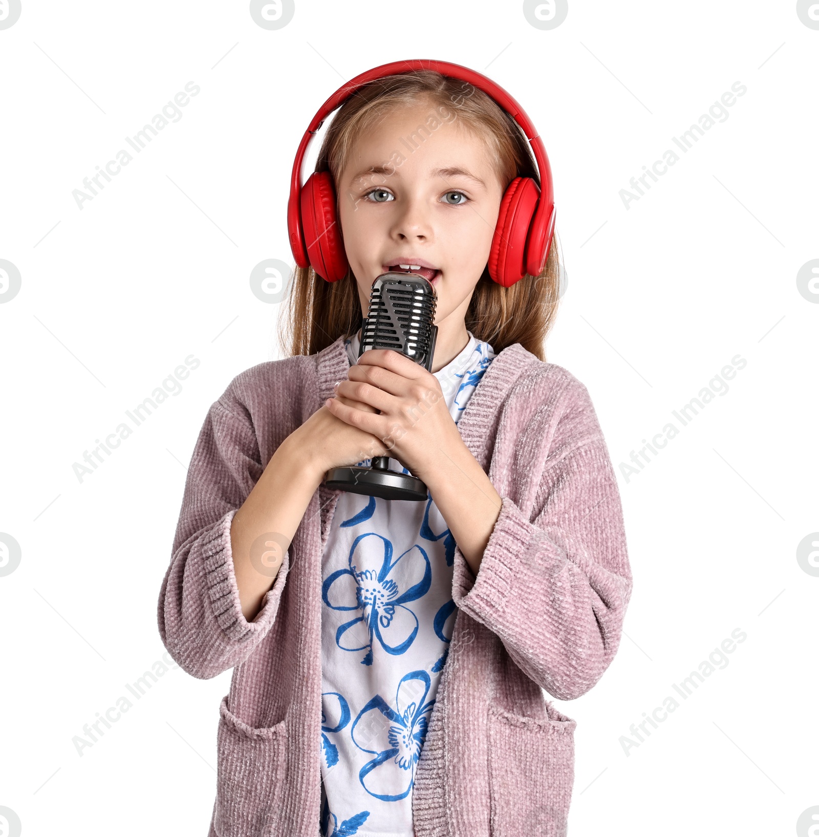 Photo of Little girl with microphone and headphones singing on white background