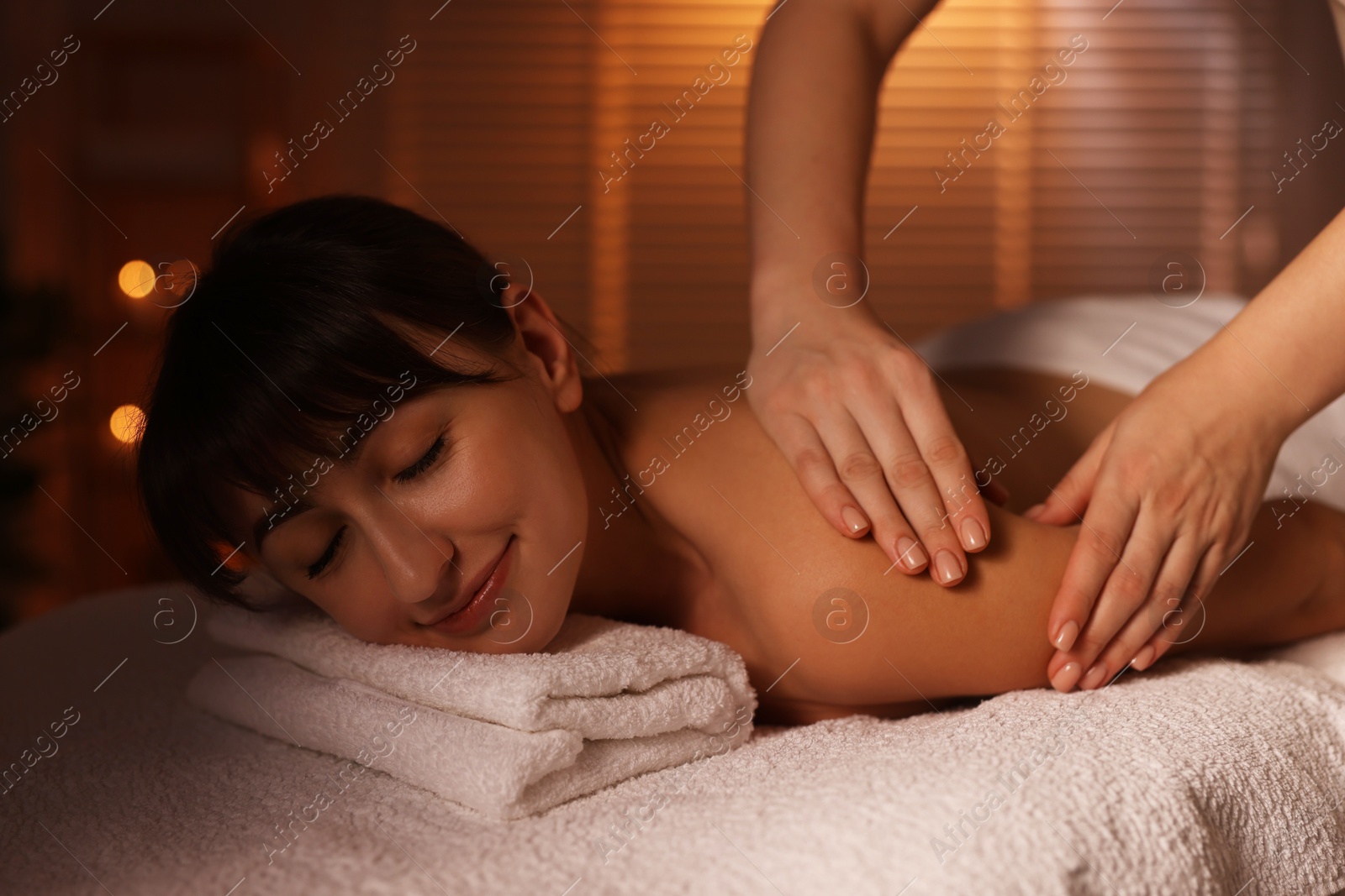 Photo of Young woman receiving massage in spa salon