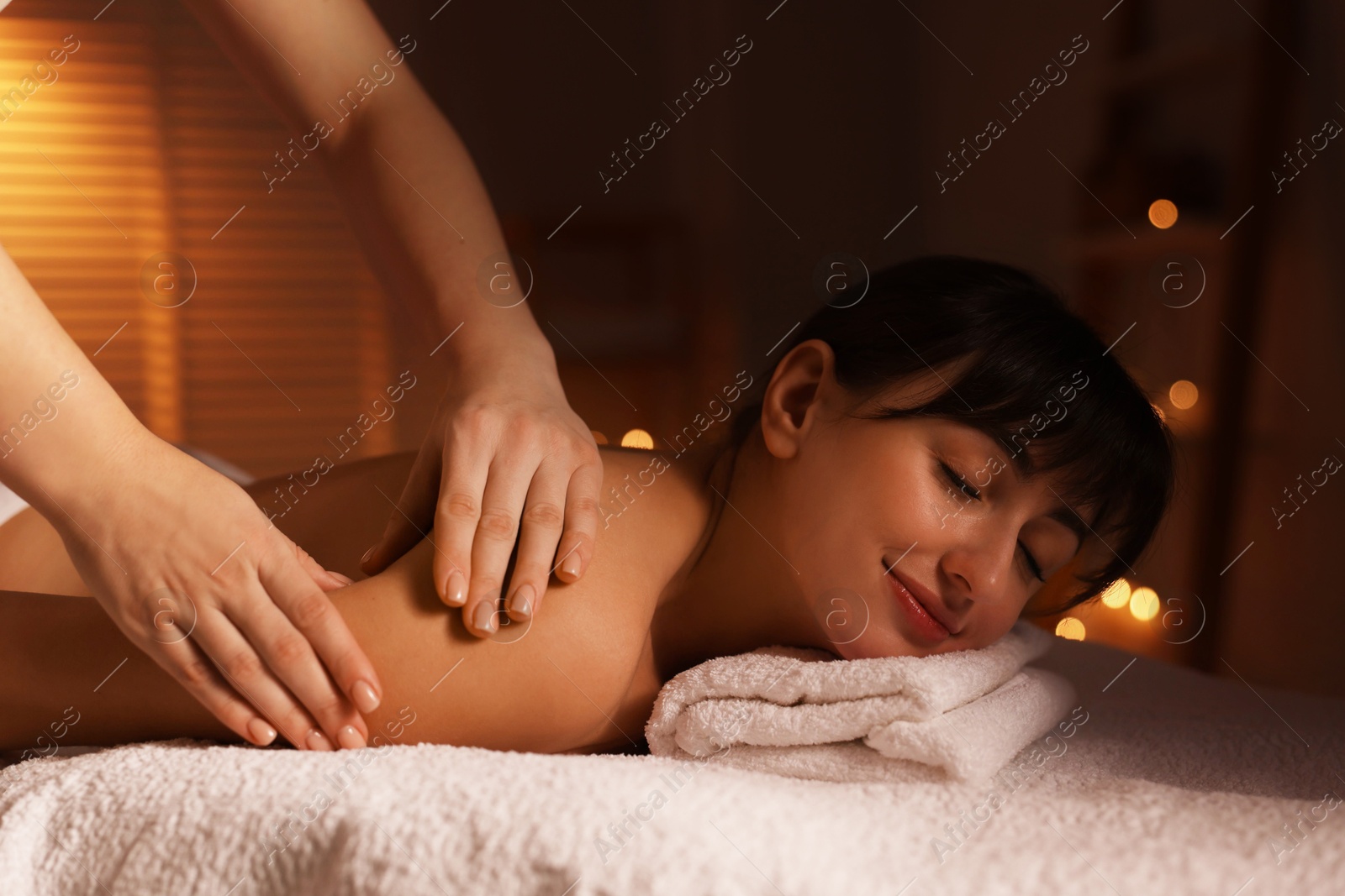 Photo of Young woman receiving massage in spa salon