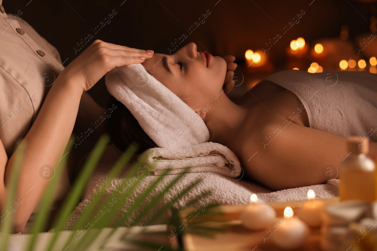 Photo of Young woman receiving massage in spa salon