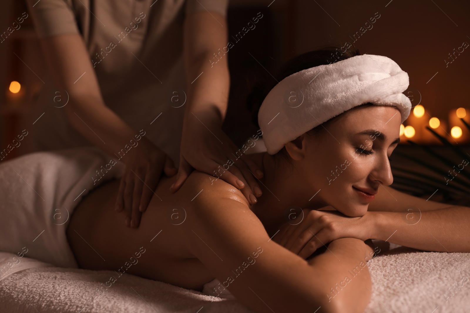 Photo of Young woman receiving massage in spa salon