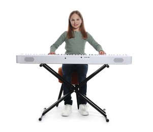 Photo of Cute girl playing synthesizer on white background