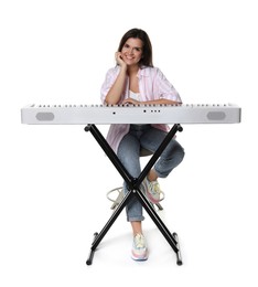 Photo of Beautiful woman posing with synthesizer on white background