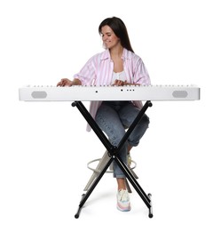 Smiling woman playing synthesizer on white background