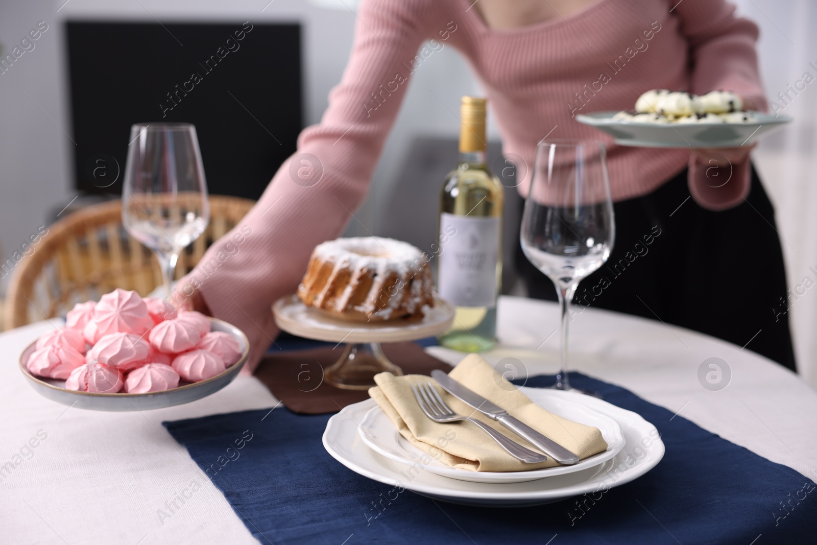 Photo of Woman setting table for dinner at home, closeup