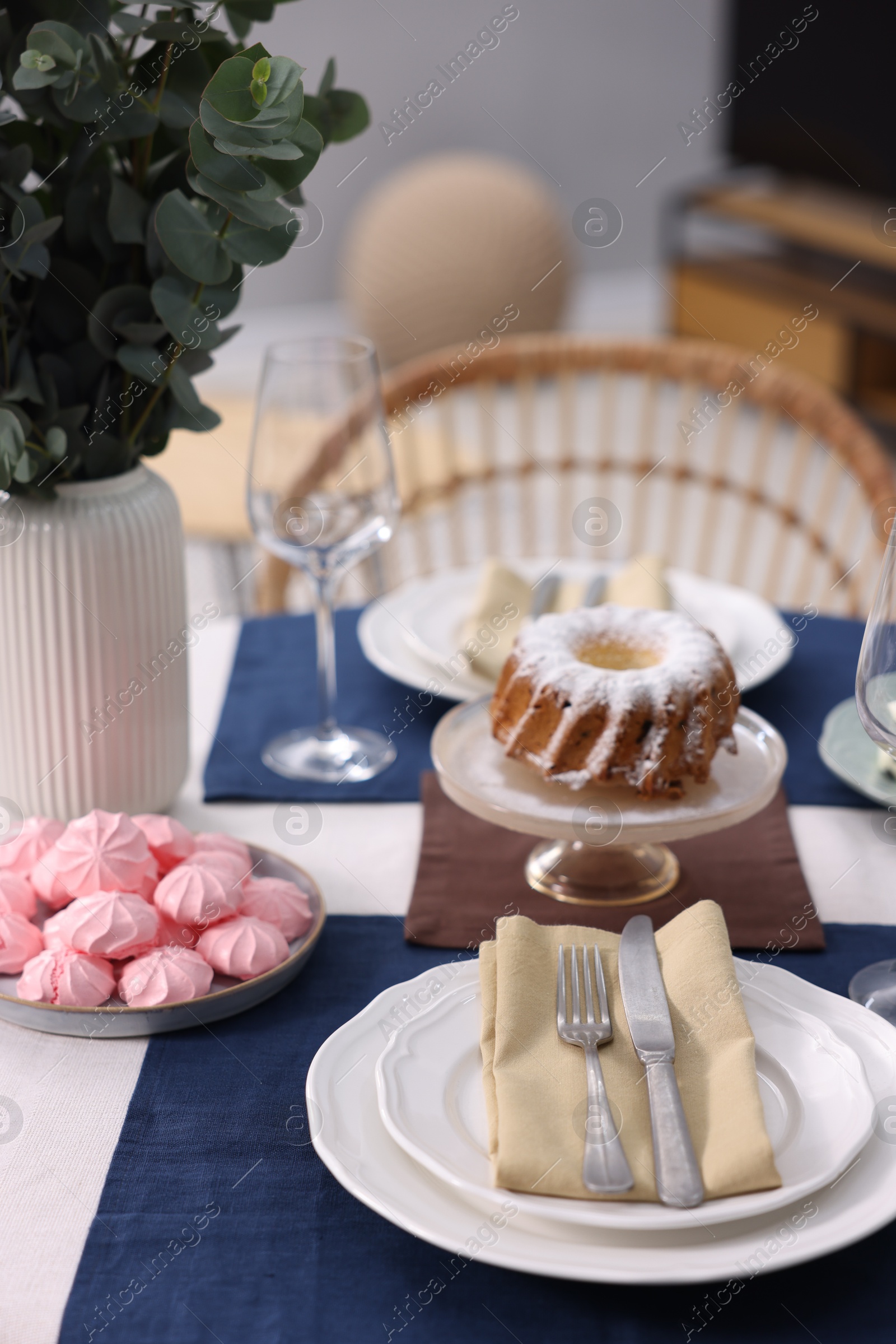 Photo of Festive table setting with dishware, cutlery and desserts indoors