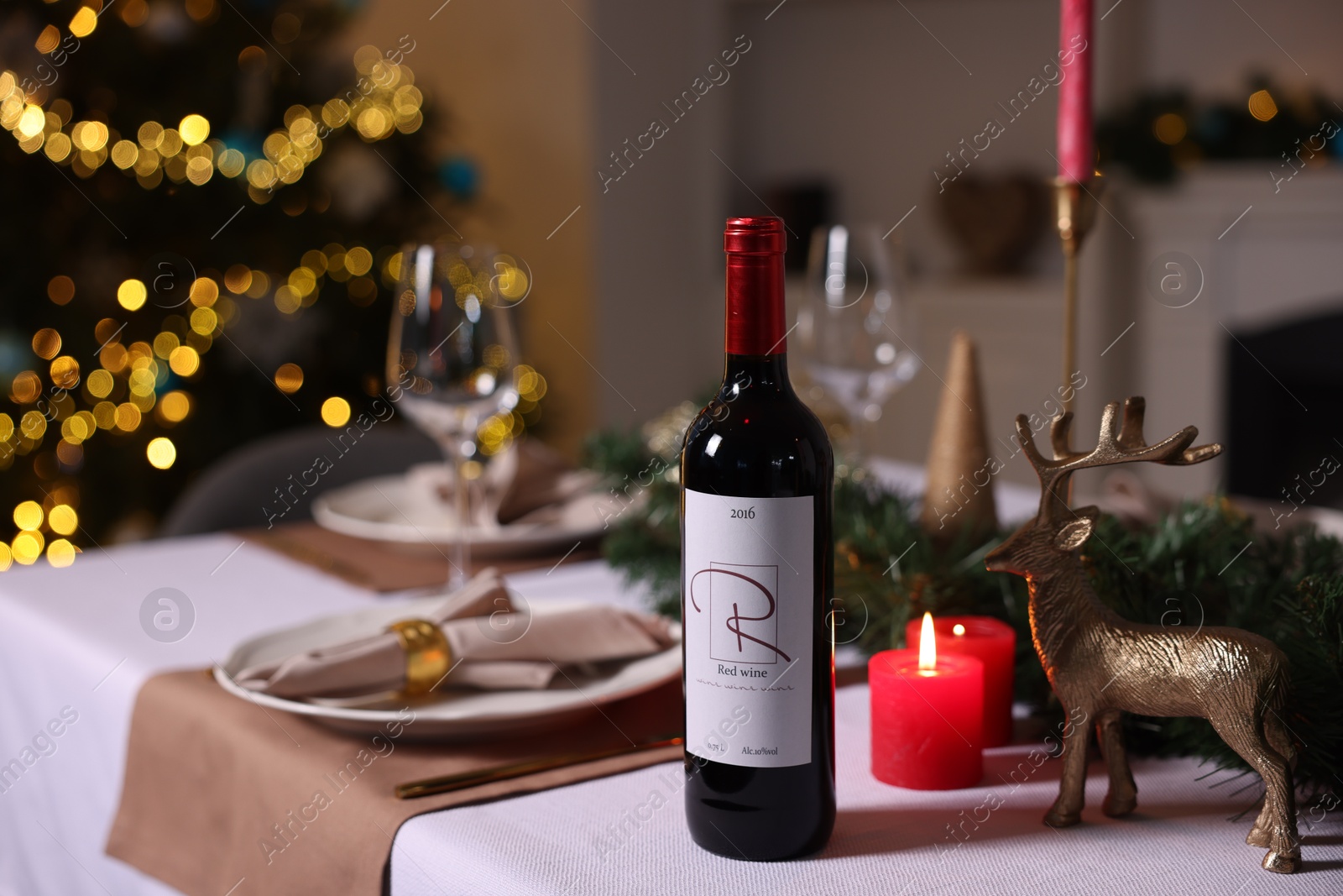 Photo of Festive table setting with dishware, wine and decor indoors