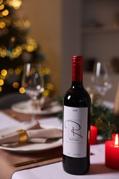 Photo of Festive table setting with dishware, wine and decor indoors