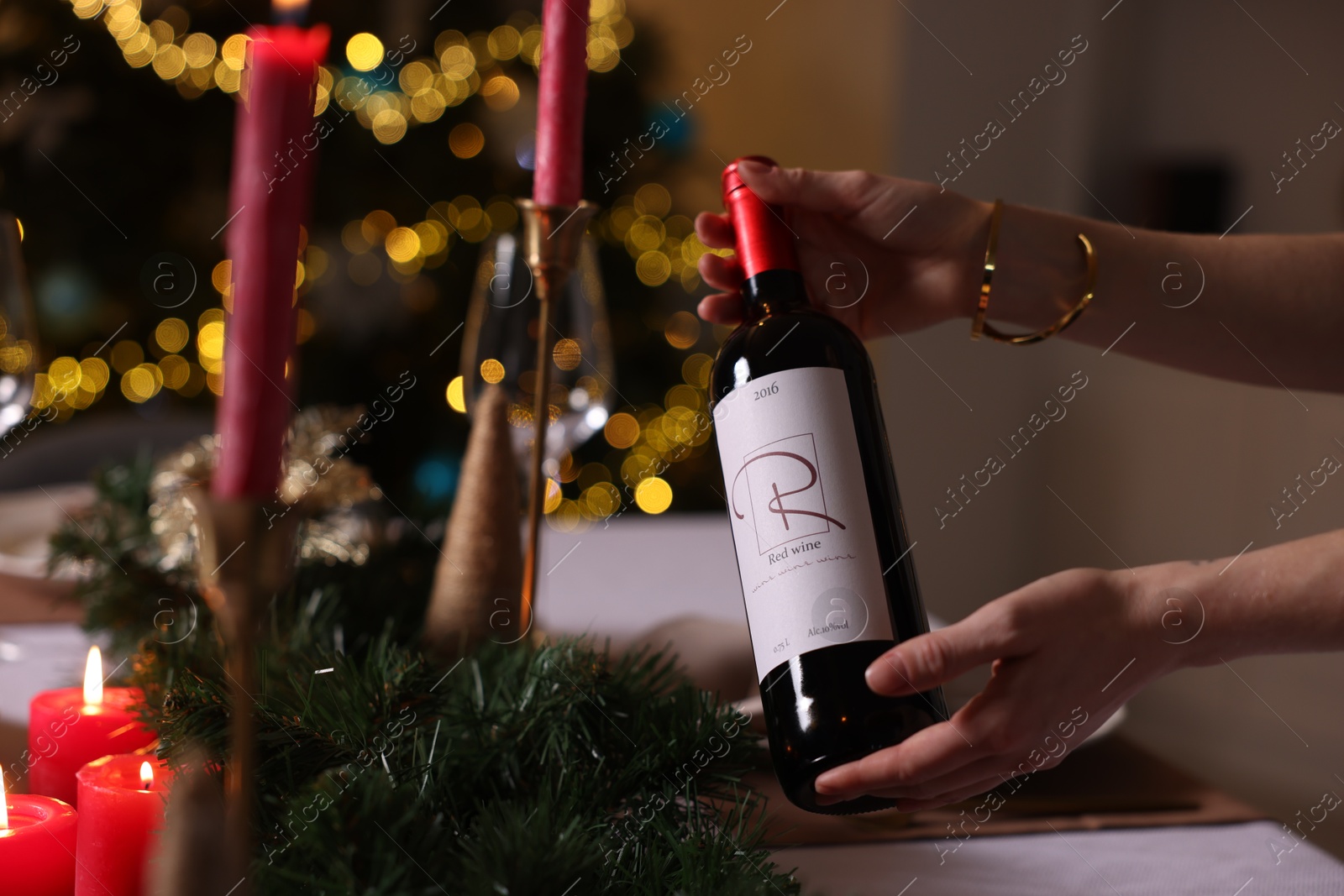 Photo of Woman setting table for Christmas dinner at home, closeup