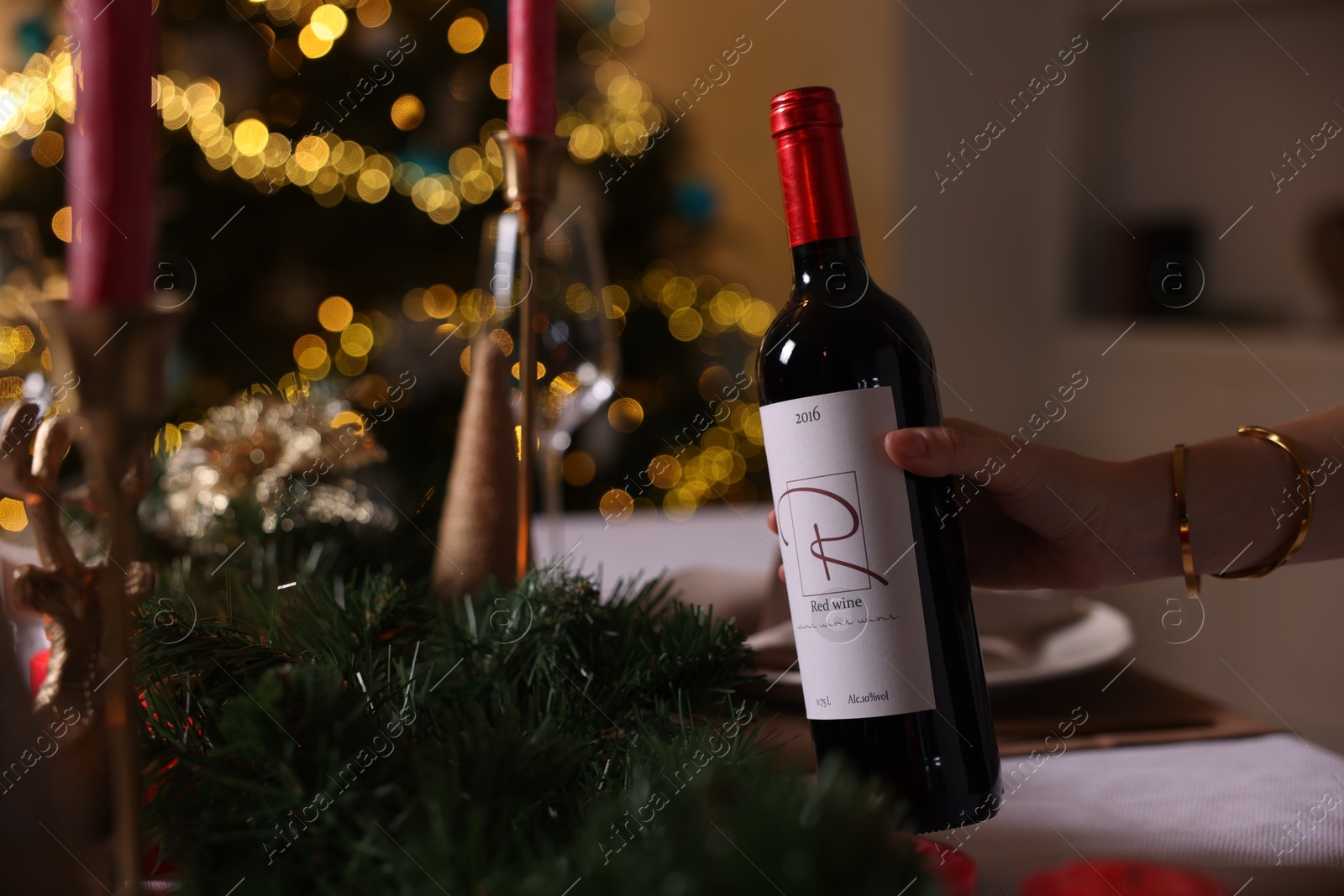 Photo of Woman setting table for Christmas dinner at home, closeup