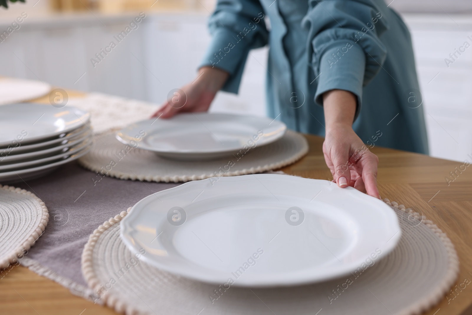 Photo of Woman setting table for dinner at home, closeup