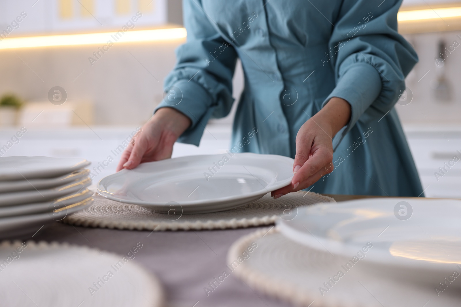 Photo of Woman setting table for dinner at home, closeup