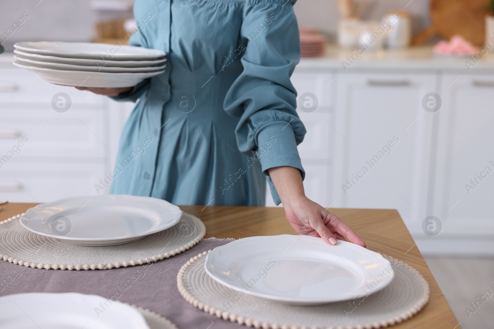 Photo of Woman setting table for dinner at home, closeup