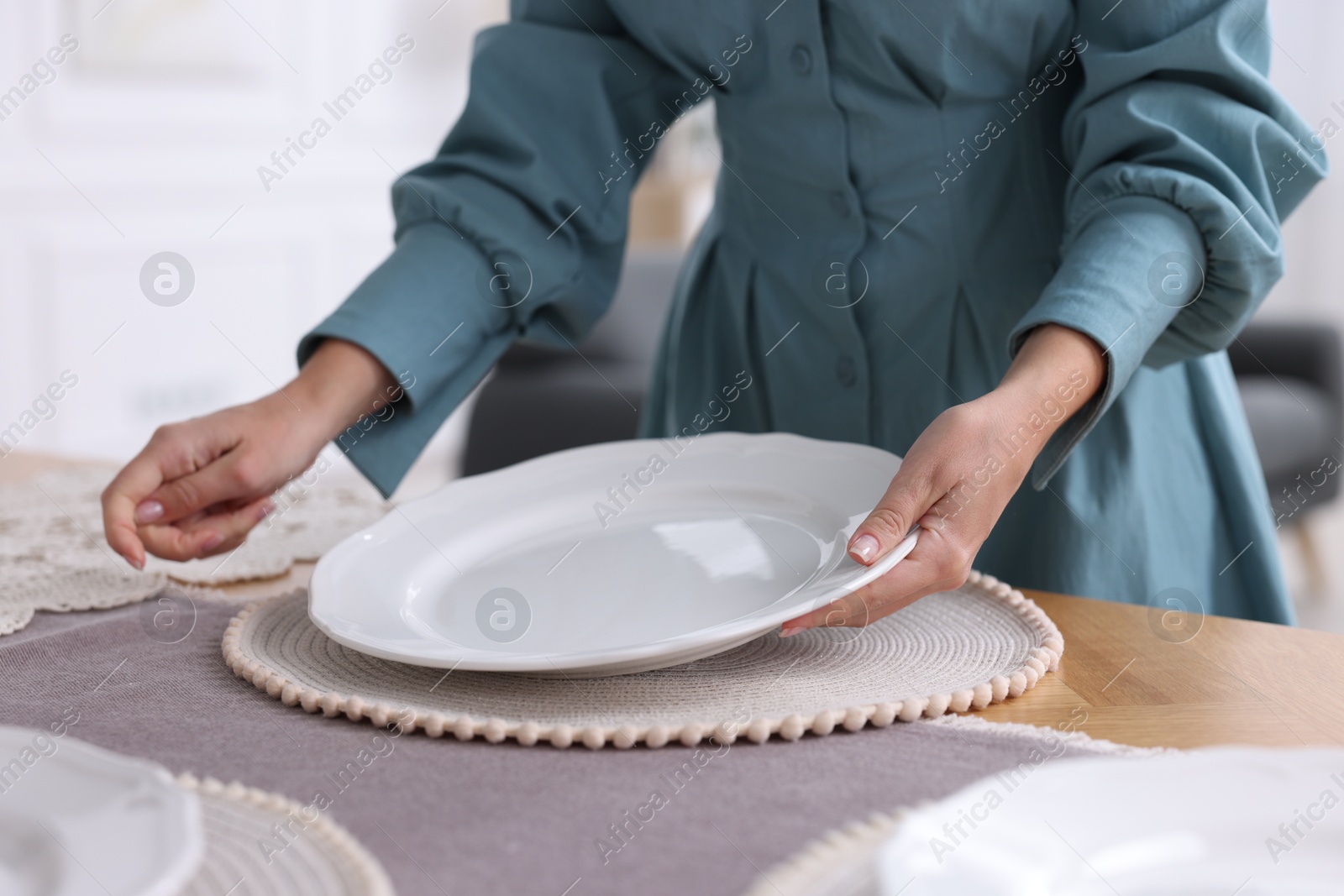 Photo of Woman setting table for dinner at home, closeup